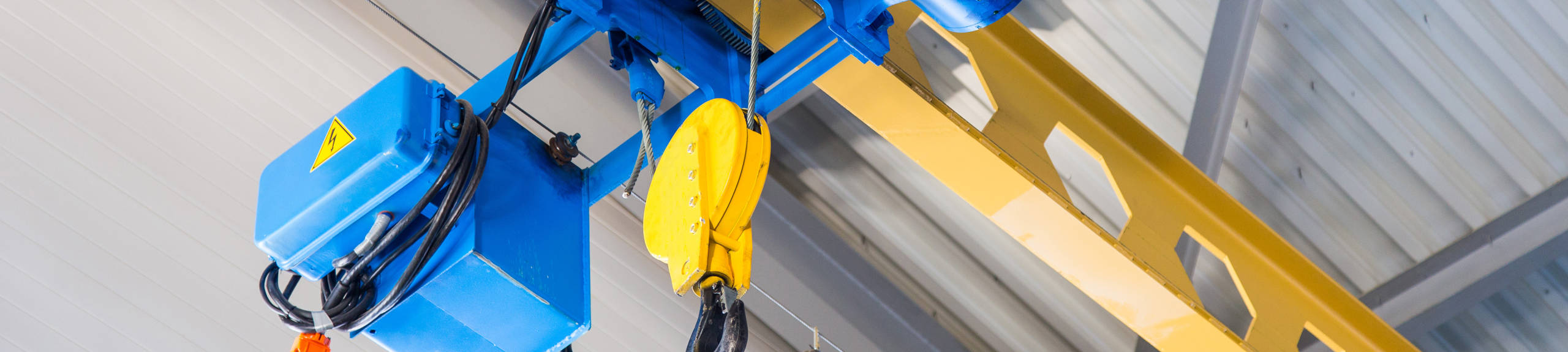 A yellow and blue overhead warehouse crane.